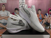 Angled side view showing the white and silver-gray upper, black Swoosh, circular side emblem, and ZoomX branding.