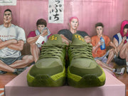 Front view of green sneakers with matching laces and layered green panels