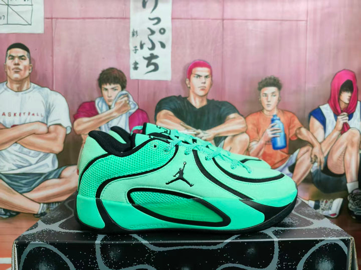 Side view of green and black Jordan basketball sneakers displayed on a patterned box.