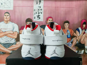 Rear view of the white high-top sneakers showing ankle straps, red collar lining, and Jordan logos.
