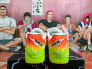 Rear view of orange and neon green Nike sneakers with white collars and black heel lettering.