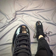 Top-down view emphasizing the glossy black toe box, black laces, and padded tongue.