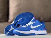 Three-quarter view of a blue sneaker beside its outsole, showing the textured tread and white side branding.