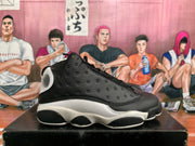 Side profile of a black and white high-top sneaker showing perforated panels, a white midsole, and black outsole sections.