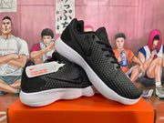 Angled view of two black Nike sneakers showing the Swoosh, patterned upper, tongue details, and white ridged soles.