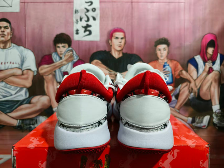 Rear view of white Nike basketball shoes with red collars, patterned heel panels, and red outsoles.
