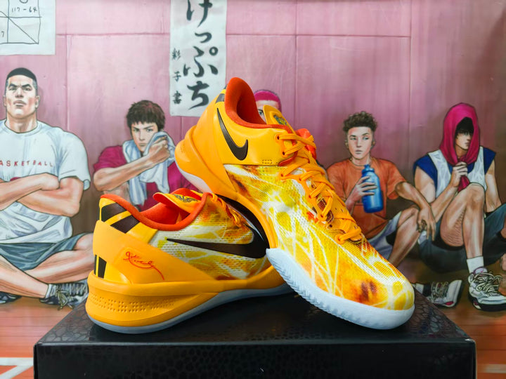Yellow and orange Nike basketball shoes shown from the side and at an angle.