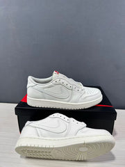 White low-top Jordan sneakers shown from the side and underside, highlighting the layered upper and circular outsole tread.