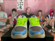 Front view of Nike sneakers with white and gray uppers, bright green laces, blue toe accents, and black toe panels.