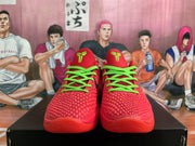 Front view of red Nike basketball sneakers with textured uppers, bright green laces, and matching green tongue logos.