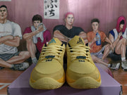 Front view showing yellow perforated toe boxes, woven laces, dark trim, and contrasting tongue details.