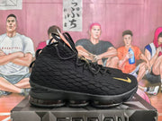 Side view showing the textured black upper, gold Swoosh accent and layered sole.
