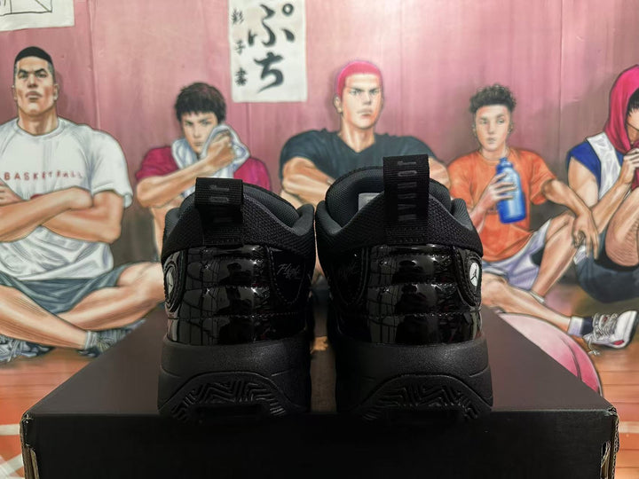 Rear view of a pair of black Jordan sneakers showing glossy heel panels, pull tabs, and Jumpman logos.