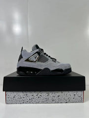 Single gray and black Air Jordan 4 Retro sneaker shown in side profile on a speckled shoebox.
