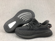 Outsole view of the black sneaker pair with visible adidas branding and heel insert.