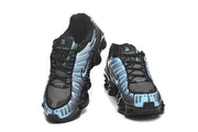 Front view of a pair of black and blue Nike Shox TL sneakers.