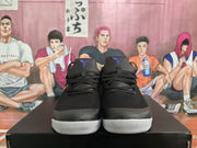 Front view of black lace-up Nike basketball shoes with purple tongue details and white toe outsoles.