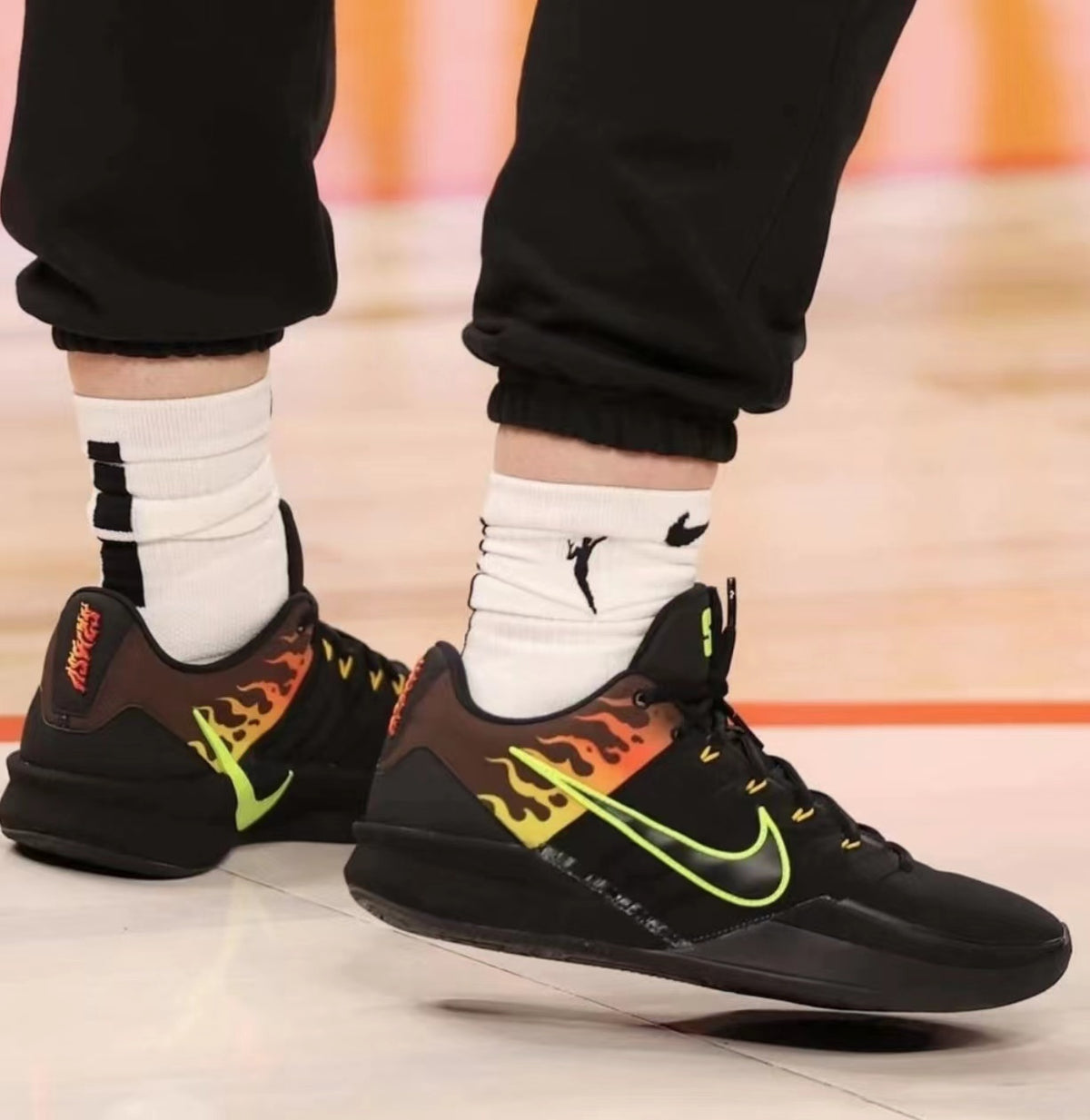 Black Nike Kobe 6 basketball shoes with neon green Swoosh accents and flame-patterned side panels