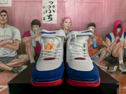 Front view of the white, blue, and red Nike basketball sneakers with laces and padded collars.
