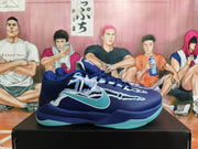 Side view of a deep blue basketball shoe with aqua accents, perforated panels, and graphic detailing