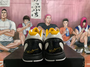 Rear view of the sneakers showing black heel panels, yellow collar lining, and gold-colored heel details.