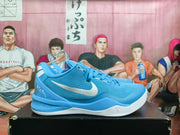 Side profile of a royal blue Nike basketball sneaker showing the Swoosh, perforated upper details, and textured midsole.