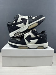 Two black-and-white sneakers arranged on a shoebox, showing both side profiles and contrasting translucent outsole sections.
