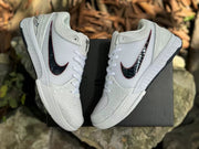 Pair of Kobe 4 shoes displayed above a dark shoe box