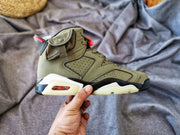 Outer side profile of the olive high-top sneaker with layered panels and visible heel cushioning detail.