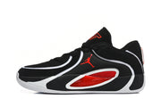Side profile of a black basketball sneaker with white trim, red mesh-style side panel, and a white outsole.