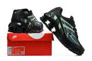 Pair of black, teal, and pale green Nike Shox Ride 2 sneakers displayed with a red shoe box.