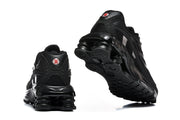 Rear and outsole views of black Nike Shox Ride 2 sneakers, showing heel detailing and the sculpted sole.