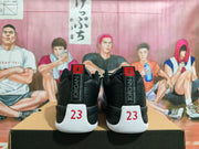 Rear view of black and white Jordan Jumpman sneakers showing vertical Jordan branding and red 23 heel details.