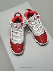 Top-down view showing the white laces, red collars, tongue branding and red toe sections.