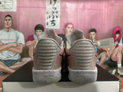 Rear view showing the padded heel sections and speckled heel soles of the gray and pink sneakers.