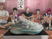 Side profile of a grey-blue Nike basketball sneaker with textured upper panels, layered midsole details, and a translucent outsole.