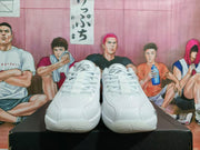 Front view of white and light gray Jordan sneakers showing the laces, perforated toe areas, and textured side panels.
