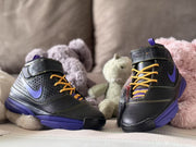 Front three-quarter product view of both sneakers with gold-yellow laces, purple accents and padded high-top collars.