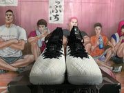 Front view of a pair of white and black high-top Nike basketball sneakers with black laces.