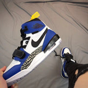Close angled view of the outer side showing the blue collar, black Swoosh-style detail, elephant-print panel, and heel unit.