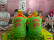 Rear view of neon yellow-green basketball shoes with orange accents and graphic heel details on a PUMA box.