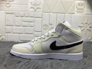 Profile view of a cream and white mid-top sneaker with white laces, black side design, and a white midsole.