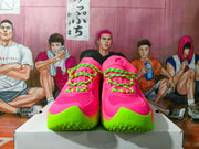 Front view of pink Under Armour sneakers with neon green toe details.