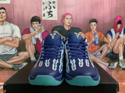 Front view of navy blue basketball shoes showing the tongue logos, laces, skeletal-style upper graphics and aqua toe accents.