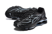 Pair of black Nike Shox R4 sneakers with light blue detailing, shown at an angle.