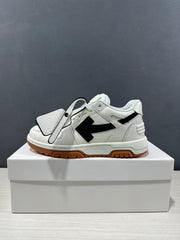Side view of a white sneaker with black arrow detailing and a hanging shoe tag.