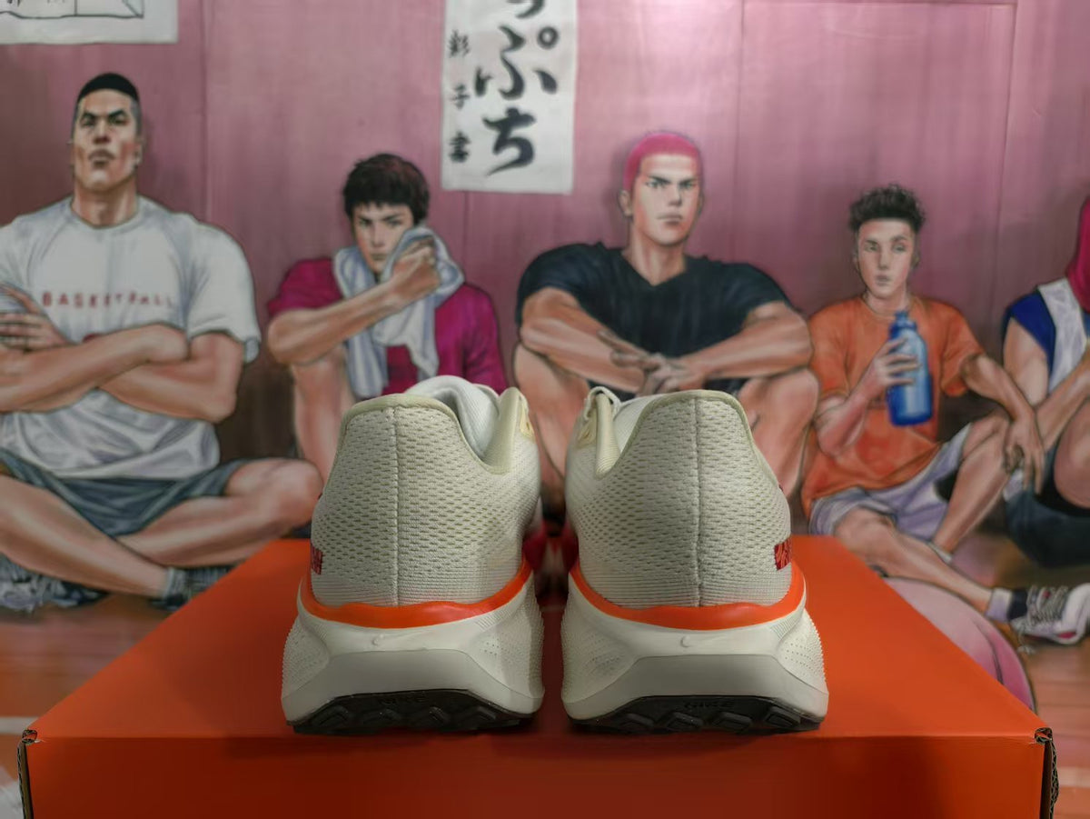 Rear view of a pair of white and red Nike sneakers on an orange box.