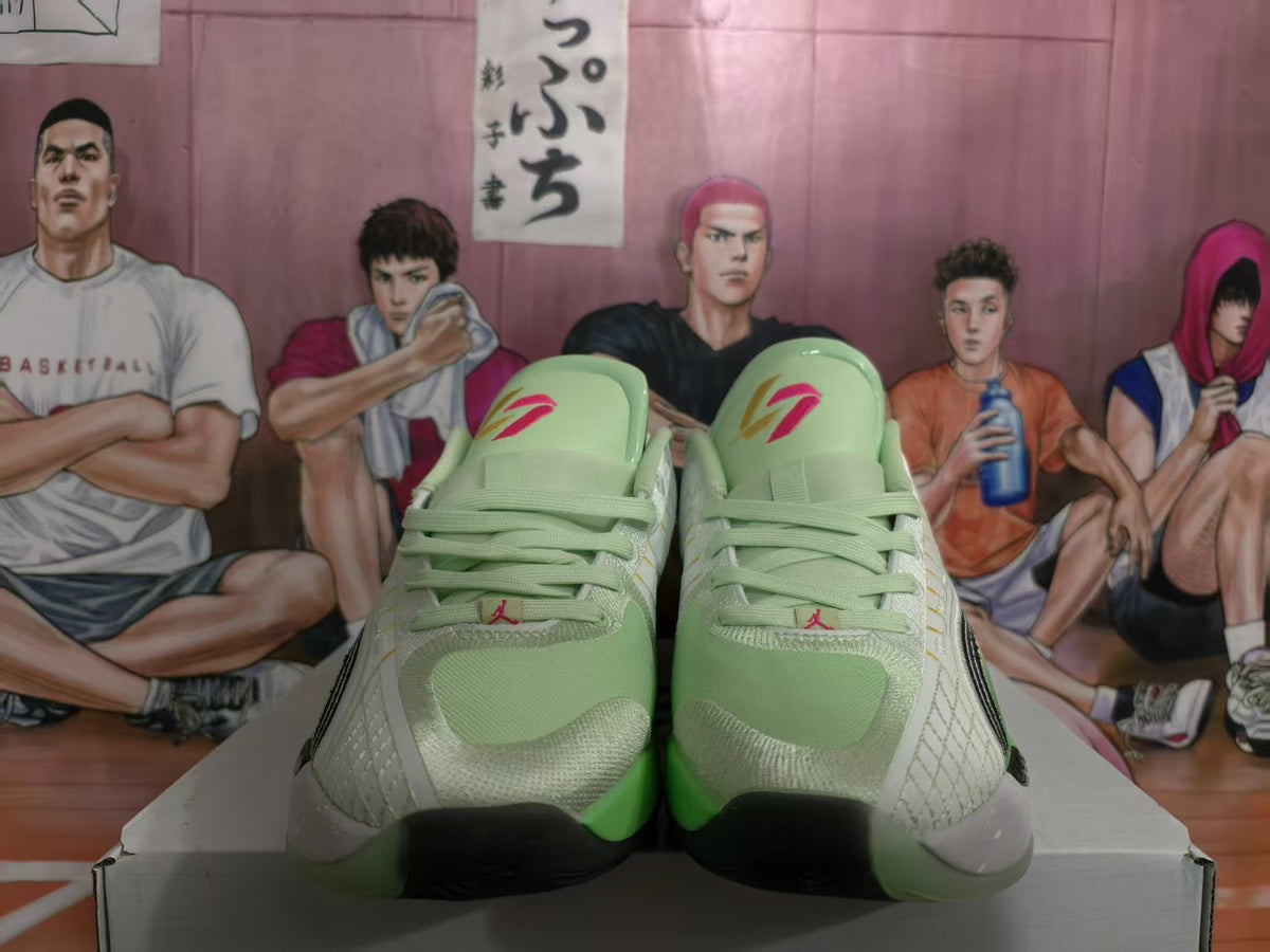 Front view of green and white Jordan basketball sneakers with contrasting black toe accents.