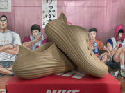 Angled view of khaki Nike sneakers displaying the perforated upper, side branding, and layered outsole.