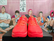 Front view of coral Nike Kobe PE basketball shoes with green accents